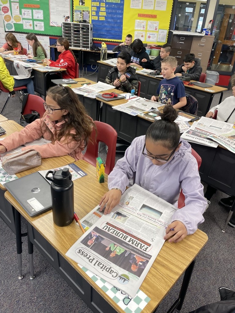 4th and 5th graders studying the elements of a newspaper